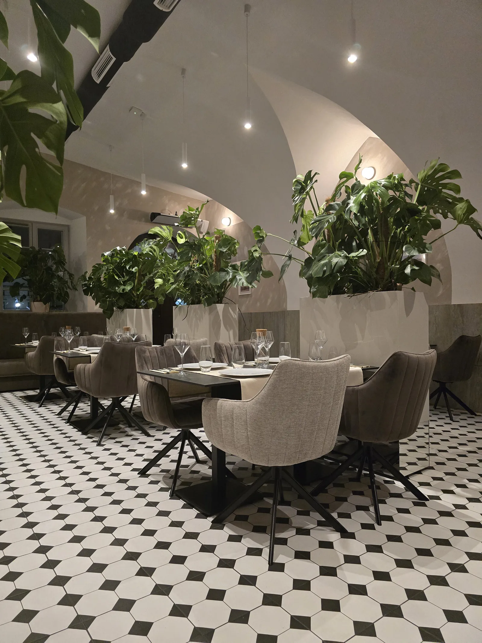 Sala restauracji z tapetą leśną i zieloną glazurą